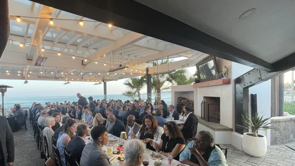 Company holiday party dinner at a long table under string lights at The Ellwood oceanfront venue in Goleta Beach